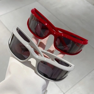 Detailed close-up of futuristic Y2K wraparound sunglasses in vibrant red and light grey