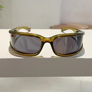 Detail view of translucent olive green Y2K wrap-around sunglasses with smoke gray lenses