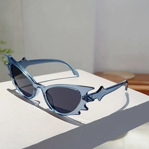 Detail of blue flame-shaped sunglasses showing the transparent frame and black lenses