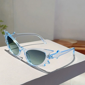 Detail of light blue flame-shaped sunglasses with serrated edges and gradient lenses