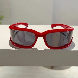 Detail of red oversized Y2K shield sunglasses with futuristic wrap-around frame design