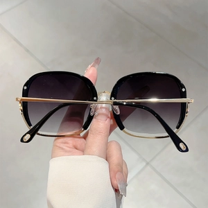 Close-up of luxury square sunglasses with gradient lenses and gold metal frame details
