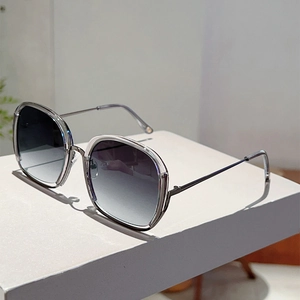 Detail of square gradient sunglasses with transparent grey frame and sleek metal temples