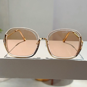 Detailed close-up of square metal frame sunglasses with peach gradient lenses