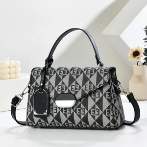 Detail of geometric pattern on women's flap bag with silver clasp and black handle