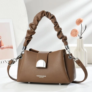 Brown lychee leather handbag with pleated handle and silver metal clasp on elegant background