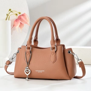 Brown lychee leather handbag with heart pendant and soft aesthetic lighting