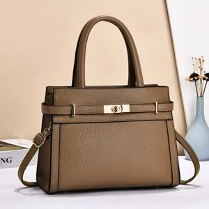 Detail of classic brown lychee texture leather handbag with elegant gold twist lock hardware