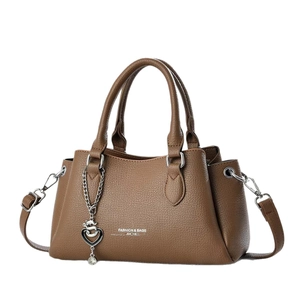 Brown faux leather crossbody handbag with dual handles and heart charm pendant
