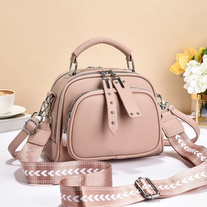 Close-up of dusty pink litchi grain faux leather bag with stylish patterned strap