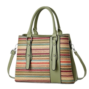 Rainbow woven straw tote bag with green leather trim and colorful striped design