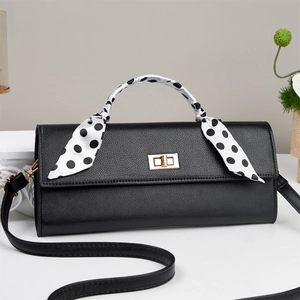 Elegant black lychee leather crossbody bag with gold lock and polka dot scarf detail