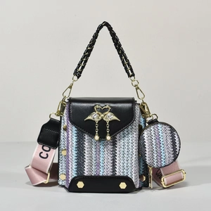 Detail of woven crossbody bag with gold swan buckle and detachable coin purse accessory