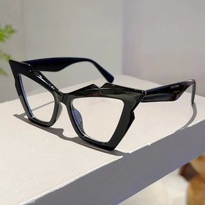 Detail of black cat-eye glasses frame with geometric facets on a minimalist display