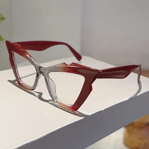 Close-up of cat-eye glasses frame with red and transparent gradient on white block