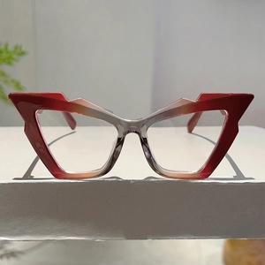 Detailed close-up of red and grey gradient geometric cat-eye glasses frames on display