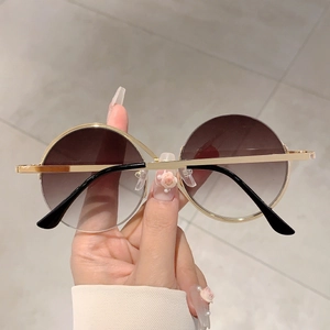 Gros plan sur des lunettes de soleil rondes rétro avec verres dégradés et monture dorée