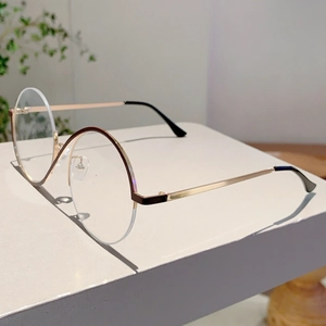 Détail de lunettes de soleil rondes demi-cerclées avec monture café et branches dorées