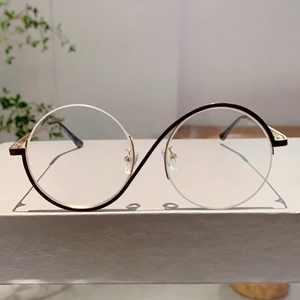 Gros plan sur des lunettes de soleil vintage avec un pont doré unique en forme de S