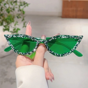 Gros plan sur des lunettes de soleil œil-de-chat avec verres verts et strass brillants