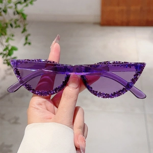 Gros plan de lunettes de soleil œil-de-chat avec monture violette et détails en strass
