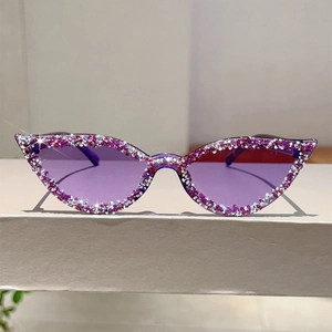 Gros plan de lunettes de soleil œil-de-chat violettes avec cristaux et verres teintés gelée