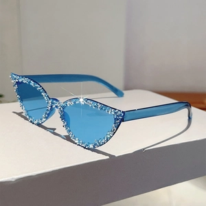 Vue détaillée des lunettes de soleil œil-de-chat bleues avec strass brillants sur la monture