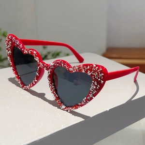Nahaufnahme der herzförmigen Sonnenbrille mit roten Strasssteinen und dunklen Gläsern