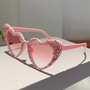 Makroaufnahme der herzförmigen Sonnenbrille mit rosa Kristallbesatz auf dem Rahmen