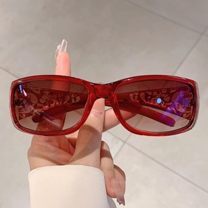 Detail of red oversized sunglasses featuring vintage floral patterns on lenses