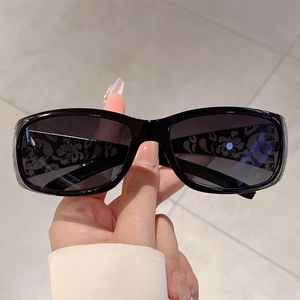 Detail of floral printed lenses on chic black sunglasses with silver accents