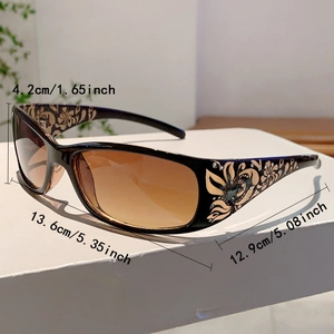 Detailed side view of women's sunglasses with gold floral patterns and rhinestone accents