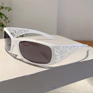 Detail of white sunglass frames with floral engraving and crystal studs on temples