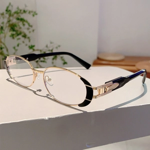 Détail de lunettes de soleil ovales en métal doré avec charnières et accents noirs