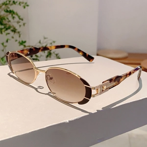 Détail de lunettes de soleil ovales en métal avec texture écaille et verres dégradés
