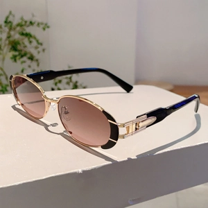 Détail de lunettes de soleil ovales en métal avec monture dorée et verres dégradés