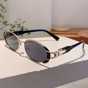 Vue latérale de lunettes de soleil ovales rétro avec monture dorée et branches