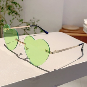 Macro shot of green heart-shaped rimless sunglasses lens with gold metal screws and bridge