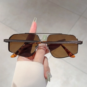 Detail of metal double bridge sunglasses with gradient brown lenses and textured arms