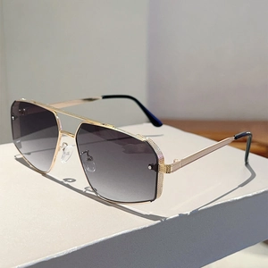 Detail of gold metal temples with intricate carvings on irregular polygon sunglasses