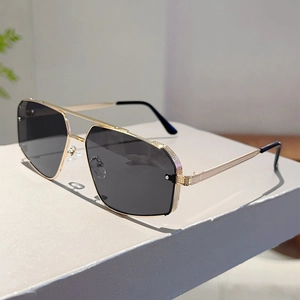Detail of pilot sunglasses with double bridge and textured gold metal temples