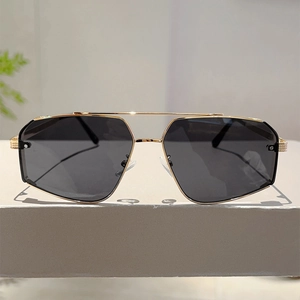 Detail showing the intricate diamond-pattern engraving on the gold metallic sunglasses arm