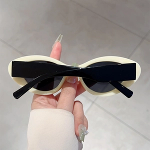 Detail of retro cream white cat eye sunglasses with thick frames and dark lenses