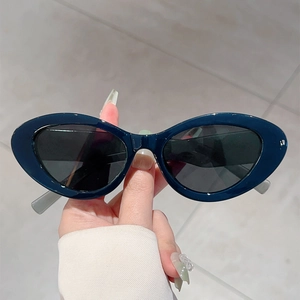 Detailed close-up of dark blue cat-eye sunglasses with polished frames and dark lenses