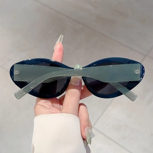Macro detail of vintage deep teal cat-eye sunglasses with translucent arms