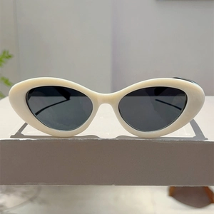 Front view of white cat-eye sunglasses with thick glossy frames and dark lenses