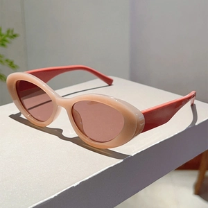 Close-up of retro cat-eye sunglasses with cream frames and coral contrast temples