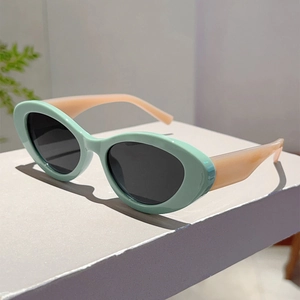 Detailed side view of mint green cat-eye sunglasses with contrasting peach pink temples