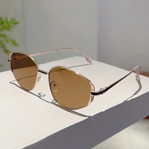Close-up of brown polygonal sunglasses lenses with rose gold metal frames on display