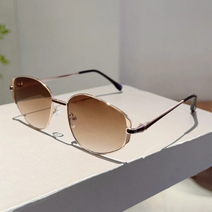Detail of rose gold geometric sunglasses with brown gradient lenses on display stand